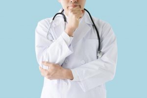顎を触り考える医師